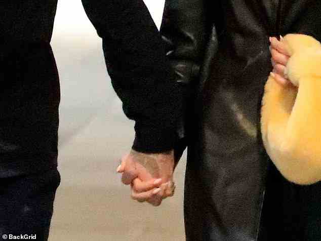 Staying close: The loved up pair tightly held hands