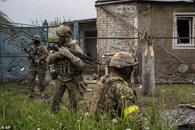 Ukrainian National Guard patrol during a reconnaissance mission in a recently retaken village on the outskirts of Kharkiv, east Ukraine, Saturday, May 14