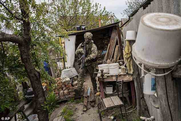 A Ukrainian National Guard soldier patrols during a reconnaissance mission in a recently retaken village on the outskirts of Kharkiv, May 14, 2022
