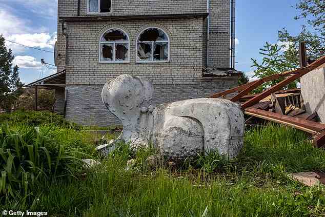 A garden statue sits next to a damaged home on May 13, 2022 on the northern outskirts of Kharkiv