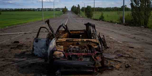 Ein zerstörtes Fahrzeug liegt am Freitag, den 13. Mai 2022, mitten auf einer Straße im Norden von Charkiw in der Ostukraine. 