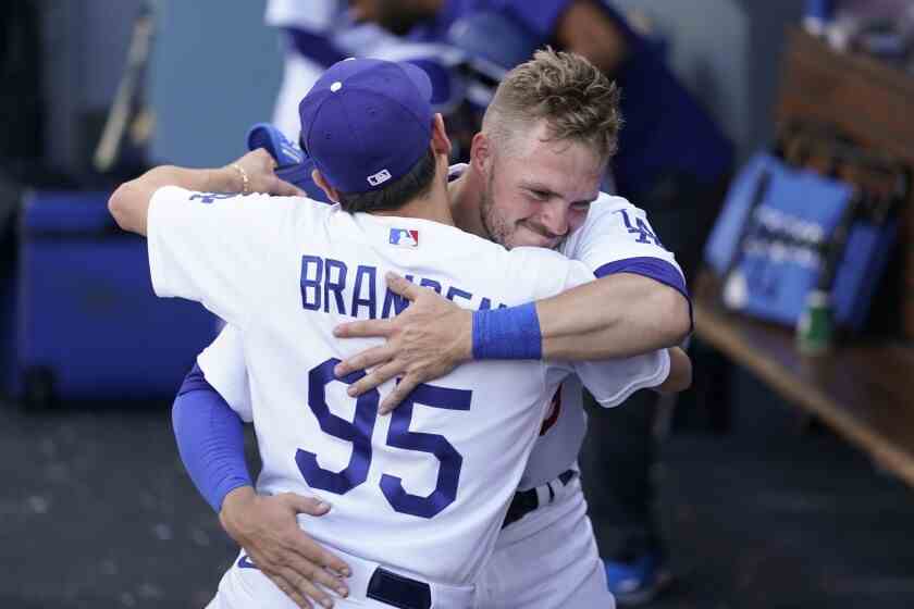 Gavin Lux wird nach dem Sieg der Dodgers am Sonntag von Batboy Branden Vandal im Dugout umarmt.