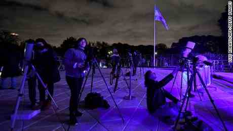 Menschen in Buenos Aires beobachten den Mond am frühen Montag während einer totalen Mondfinsternis durch Teleskope. 
