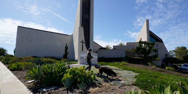 Eine K-9-Einheit der Sheriff-Abteilung von Orange County überprüft das Gelände der Geneva Presbyterian Church in Laguna Woods, Kalifornien, am Sonntag, den 15. Mai 2022, nach einer tödlichen Schießerei. 
