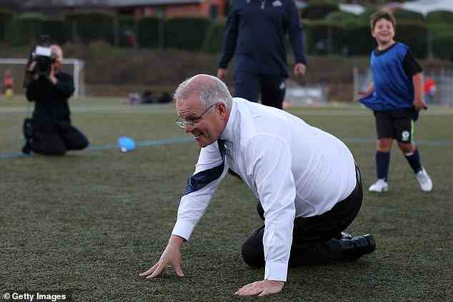 Der Premierminister betrat das Feld in seinen Geschäftsschuhen und Krawatte für den spontanen Tritt des Fußballs (Bild nach dem Stolpern).
