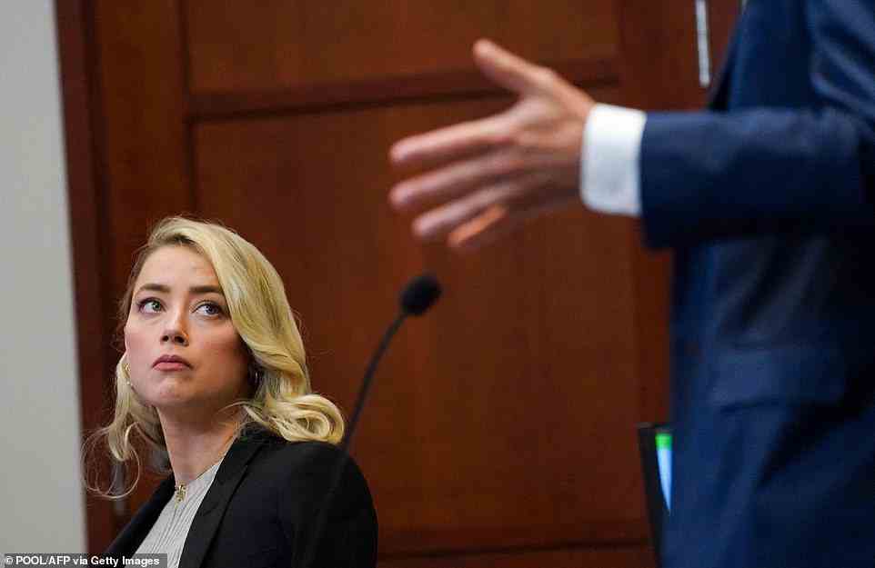 US actress Amber Heard listens during ex-husband Johnny Depp's defamation trial against her at the Fairfax County Circuit Courthouse in Fairfax, Virginia, on May 18, 2022. - US actor Johnny Depp is suing ex-wife Amber Heard for libel after she wrote an op-ed piece in The Washington Post in 2018 referring to herself as a public figure representing domestic abuse. (Photo by KEVIN LAMARQUE / POOL / AFP) (Photo by KEVIN LAMARQUE/POOL/AFP via Getty Images)