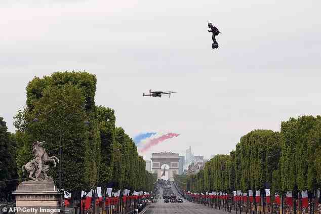 Zapata fliegt mit einem Jet-angetriebenen Hoverboard oder „Flyboard Air“, während das französische Elite-Akrobatenteam „Patrouille de France“ (PAF) am 14. Juli während der Militärparade zum Tag der Bastille auf den Champs-Elysees in Paris über den Arc de Triomphe fliegt. 2019