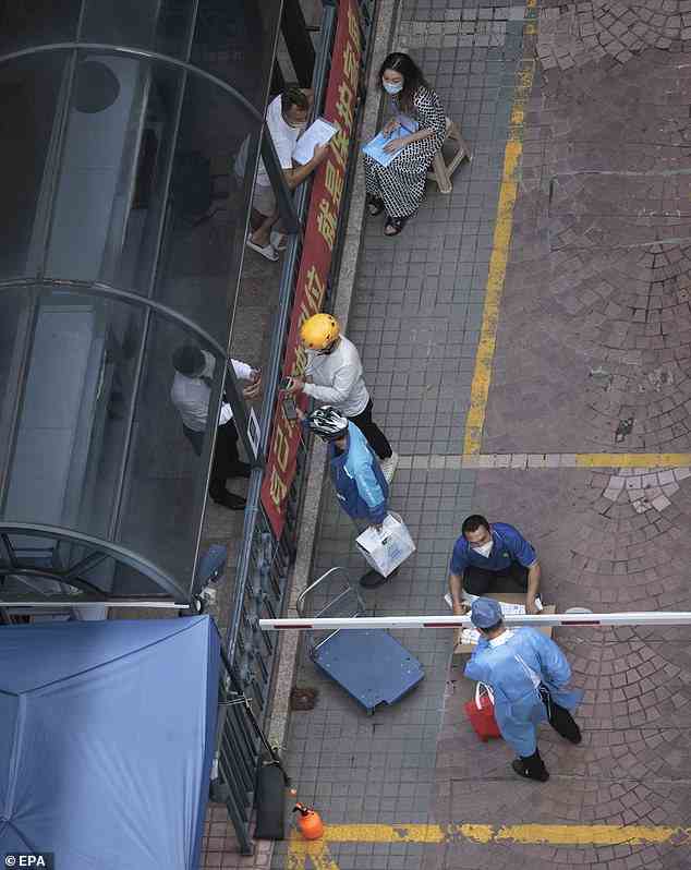 Im Bild: Arbeiter liefern Waren an ein Wohngebiet in Quarantäne in Shanghai