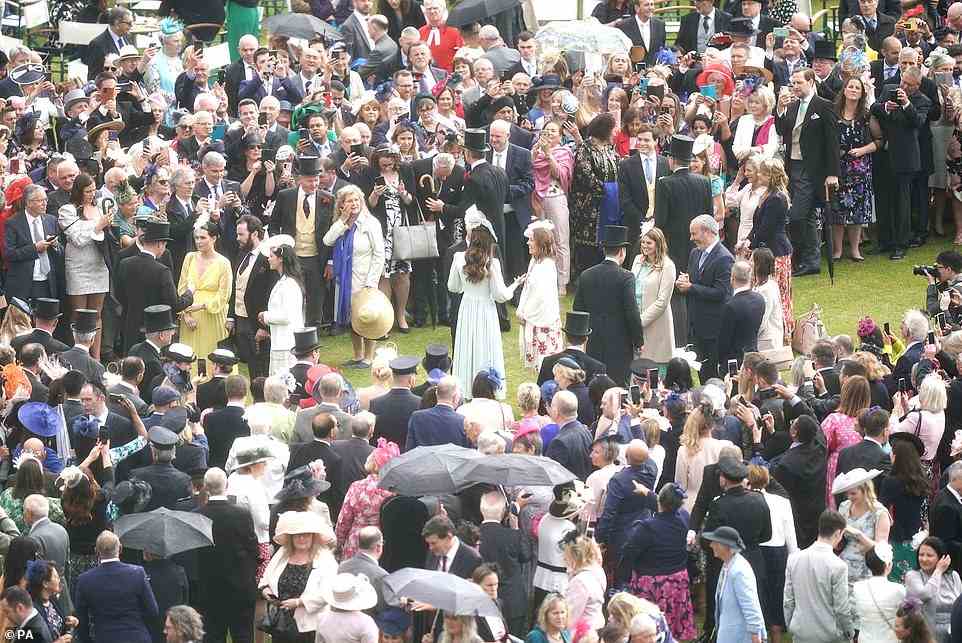 Crowds were quick to gather around the royal couple, despite the downpour, who stood and chatted with attendees (left, Prince William, and right, Kate Middleton)