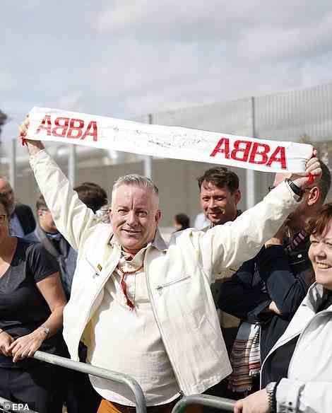 Hat die Zeit seines Lebens: Ein Fan hielt ein ABBA-Schild hoch, während er darauf wartete, die mit Spannung erwartete Show zu genießen