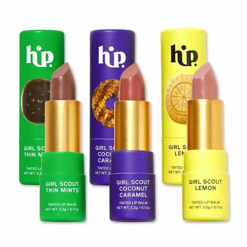 Das HipDot X Girl Scouts Lip Set, das Lippenstiftkugeln in drei verschiedenen Nude-Nuancen in einer farbenfrohen Hülle auf weißem Hintergrund enthält