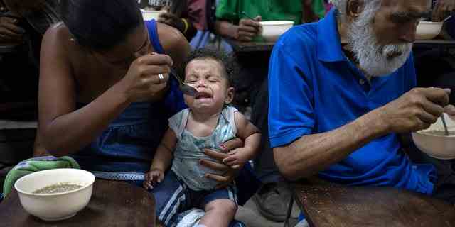 Zoraida Silva, 26, füttert ihr sechs Monate altes Baby Jhon Angel in einer Suppenküche im Slum The Cemetery in Caracas, Venezuela.  Silva sagte, dass sie es sich nicht leisten könne, 3 Mahlzeiten am Tag zu sich zu nehmen, und sie esse seit zwei Jahren in der Suppenküche. 