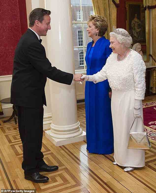 David Cameron shakes hands with Queen Elizabeth II as he arrives to attend a state dinner hosted by Irish President Mary McAllese at Dublin Castle in 2011