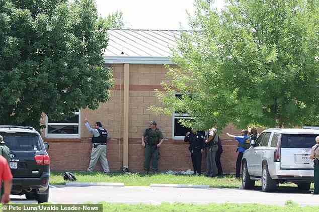 Polizisten und Grenzschutzbeamte suchen während der Schießerei am Dienstag in anderen Klassenzimmern nach Kindern