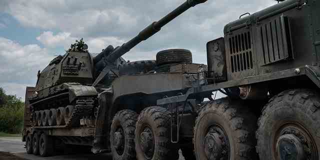 Dieses am 10. Mai 2022 aufgenommene Foto zeigt die selbstfahrende Haubitze einer ukrainischen Armee, die inmitten der russischen Invasion in der Ukraine einen Panzertransporter in der Nähe von Bachmut in der Ostukraine belädt. 