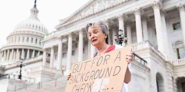 Marnie Beale aus Arlington, Virginia, hält ein Schild an den Senatsstufen des US-Kapitols und fordert am Mittwoch, den 25. Mai 2022, nach der jüngsten Massenerschießung an einer Grundschule in Texas Hintergrundüberprüfungen von Waffenkäufen
