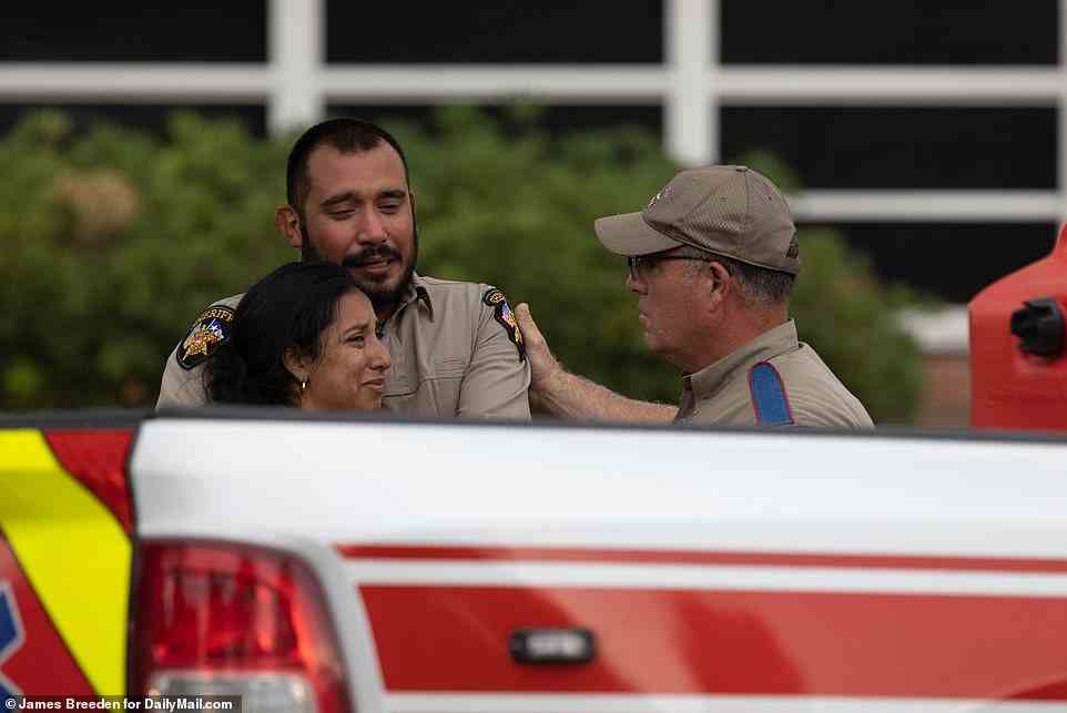 Dieses Bild von Sheriff-Stellvertreter Felix Ramos, der seine Frau Kimberly umarmt, als sie herausfanden, dass ihre Tochter Lexi, 10, unter den Opfern war, wurde in die ganze Welt gebeamt