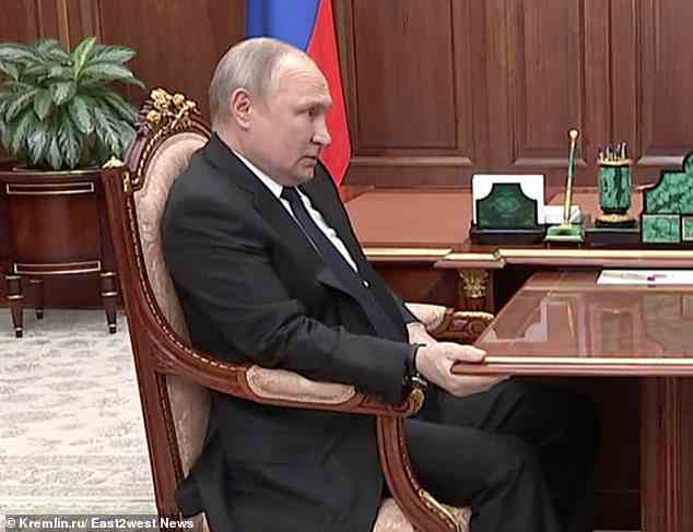 Pictured: Putin is shown clinging to his desk as he holds a meeting with Russian defence minister Sergei Shoigu. An order by Putin to strike Ukraine or the West with nuclear weapons will not be obeyed by his top commanders, a senior investigative journalist has said, amid fears amongst his inner circle that he is gravely unwell