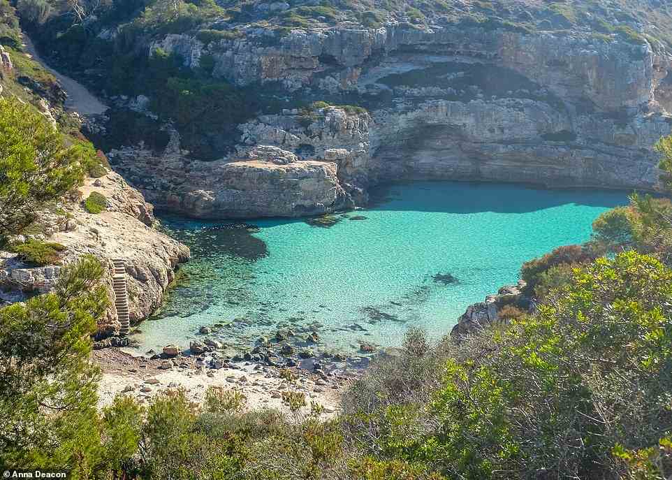 CALO DES MARMOLS, SANTANYI, MALLORCA: 'Deep in the "marble bay" this is a rugged, remote beach backed by dramatic, high cliffs [that's] accessible only on foot by a tough hike in on a scrambly coastal path,' the book reveals. The authors say 'that there are steps cut into the cliff leading down to this hidden gem, which is never over-crowded'. Better still, they note that 'the crystal-clear water shimmers in blues and turquoise over the sandy beach and there is a really great cave to swim into'. Coordinates: 39.2886,3.0896