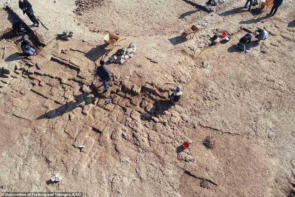 Archäologen und Arbeiter legen Mauern von Gebäuden im antiken Stadtkomplex von Kemune frei