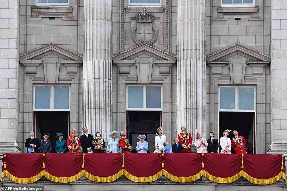 The Queen stands with members of the Royal Family to watch a special flypast from Buckingham Palace today