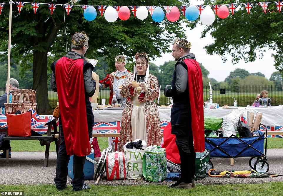 People wearing costumes of king and queen dine next a picnic table as they take part in the Big Jubilee Lunch on The Long Walk in Windsor, Britain, June 5, 2022
