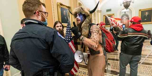 Anhänger von Präsident Trump werden von Polizisten des US-Kapitols außerhalb der Senatskammer im Kapitol konfrontiert.  (AP Photo/Manuel Balce Ceneta, Akte)