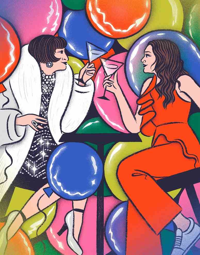 Zwei Frauen sitzen am Tisch und sehen sich mit Weingläsern in der Hand und Luftballons im Hintergrund an.