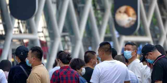 Menschen, die Gesichtsmasken tragen, stehen am zweiten Tag in Folge der Massentests in Peking am 4. Mai 2022 an einem Teststandort für COVID-19-Tests an.