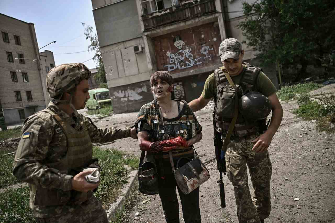 Eine verwundete Frau wird am 11. Juni während eines Artillerie-Duells zwischen ukrainischen und russischen Truppen in der Stadt Lysychansk von ukrainischen Soldaten behandelt.