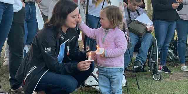 Kirsten Bridegan and her daughter Bexley at a vigil April 19 for her slain husband.