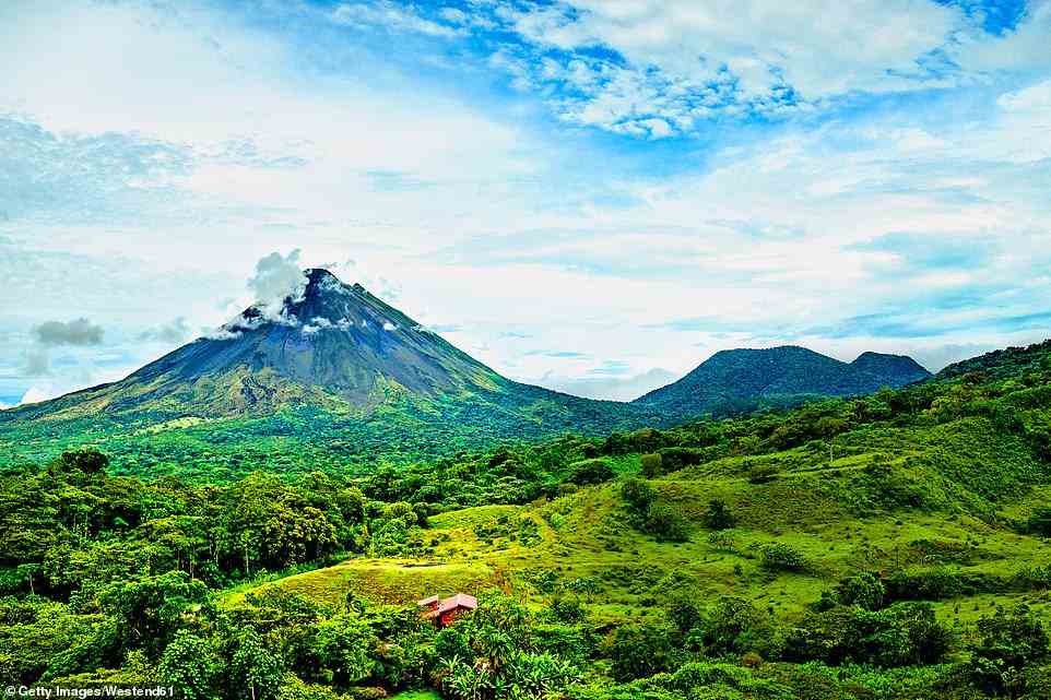 Natural wonders: Sian gets a close look at the active Arenal volcano, pictured, 'which spews threatening columns of water vapour into the air'