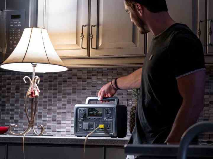 Ein Mann versorgt während eines Stromausfalls eine Lampe in einer Küche mit einem Bluetti EB3A.
