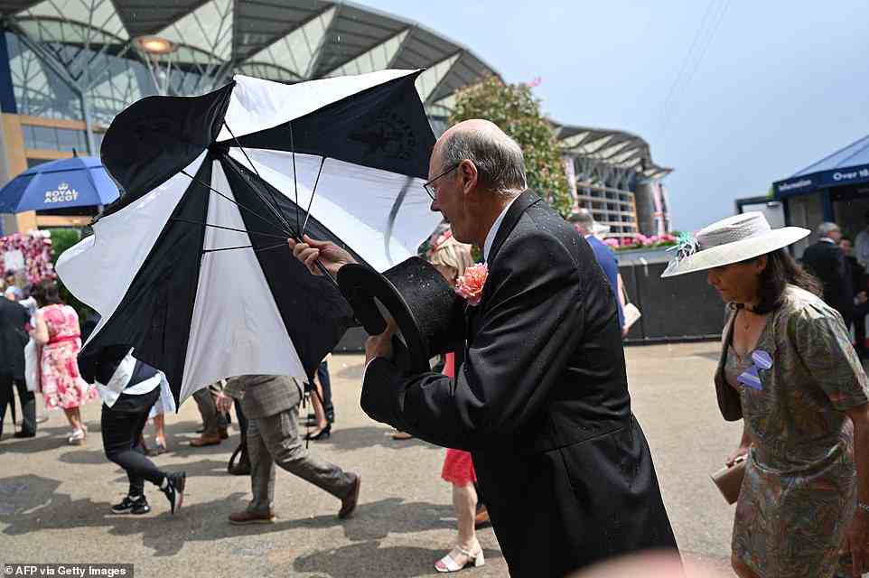 Fotos von heute zeigen Gäste, die mit Regenschirmen kämpfen, während sie versuchen, inmitten des Nieselregens trocken zu bleiben