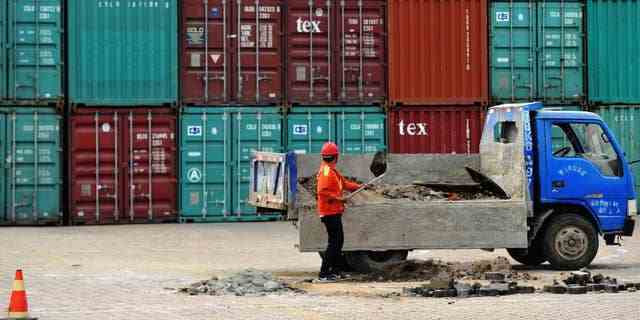 Ein Arbeiter repariert am Mittwoch, den 8. Juni 2016, den Boden in einem Containerhafen in Qingdao in der ostchinesischen Provinz Shandong. Chinas Exporte und Importe gingen im Mai erneut zurück, ein Zeichen für eine schwache globale und inländische Nachfrage.  (Chinatopix über AP) 