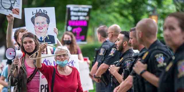 Polizisten sehen zu, wie Befürworter des Rechts auf Abtreibung am 18. Mai 2022 in Chevy Chase, Maryland, eine Demonstration vor dem Haus des US-Richters Brett Kavanaugh abhalten. 