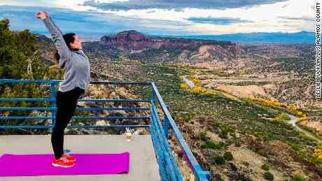Eine Frau streckt sich auf einem Aussichtspunkt in Los Alamos County, New Mexico.