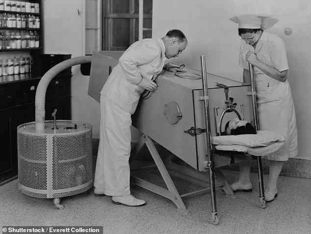 Als die Atemmuskulatur durch Kinderlähmung geschwächt wurde, wurden die Patienten früher mit einer „eisernen Lunge“ behandelt.  Im Bild: ein Polio-Patient mit eiserner Lunge im Scots Mission Hospital in Tiberias, Palästina im März 1940