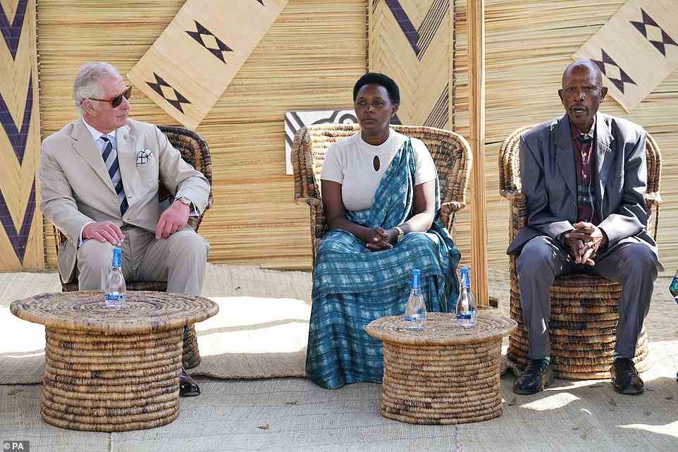The Prince of Wales listens to a genocide victim (centre) and a perpetrator who has been pardoned (right) taking about their experiences during his visit to the Mybo reconciliation village in Nyamata
