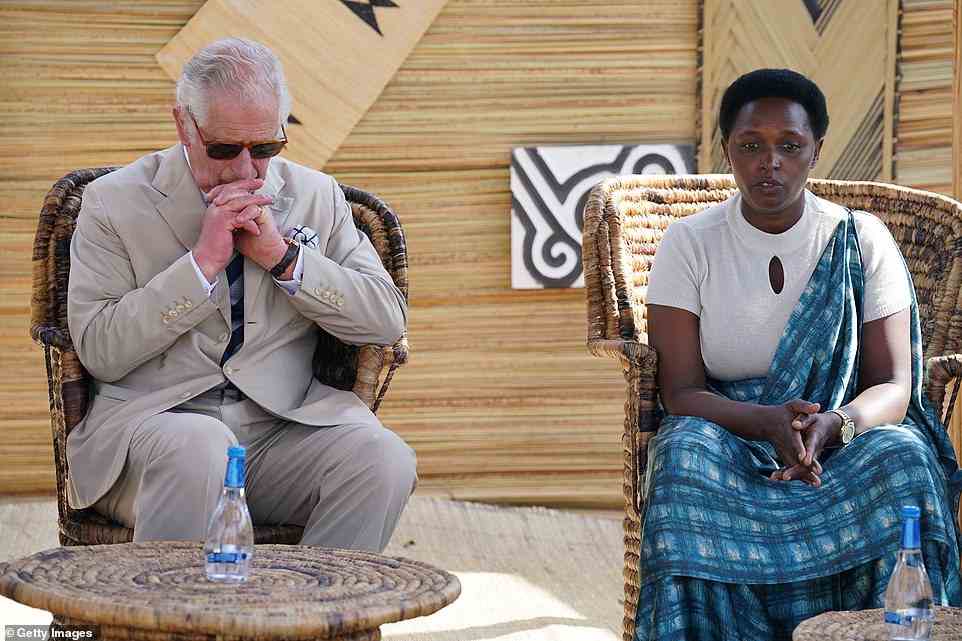 Prince Charles, Prince of Wales listens to a genocide victim during his visit to the Mybo reconciliation village in Nyamata, as part of his visit to Rwanda