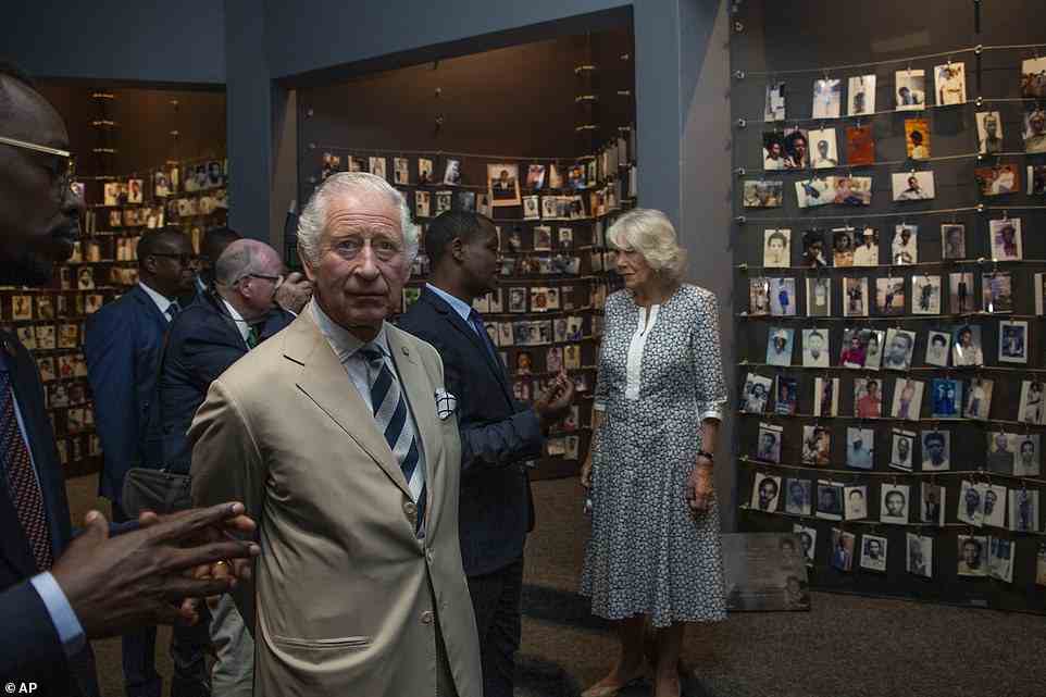 Prince Charles and Camilla, Duchess of Cornwall, observe an exhibition of family photographs of some of those who died, at the Kigali Genocide Memorial in the capital Kigali