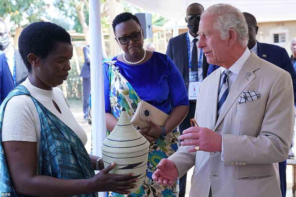 The Prince of Wales receives a basket as a gift during his visit to the Mybo reconciliation village in Nyamata