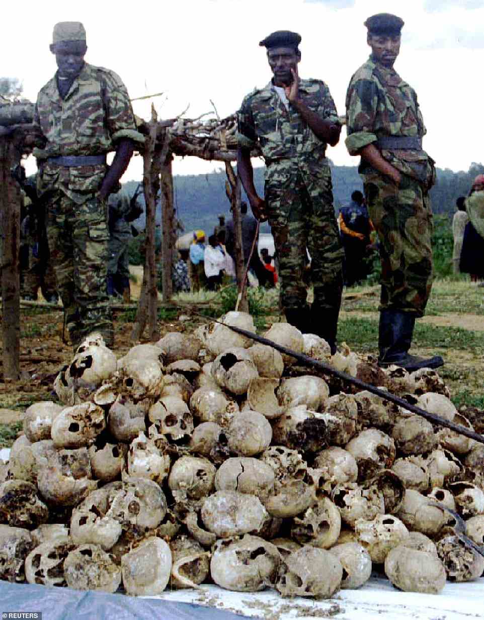 Tutsi Rwandan Patriotic Front troops look over a pile of skulls dug up to be reburied in a memorial for approximately 12,000 Tutsi massacred by Hutu militia in and around the western town of Kaduha in 1994