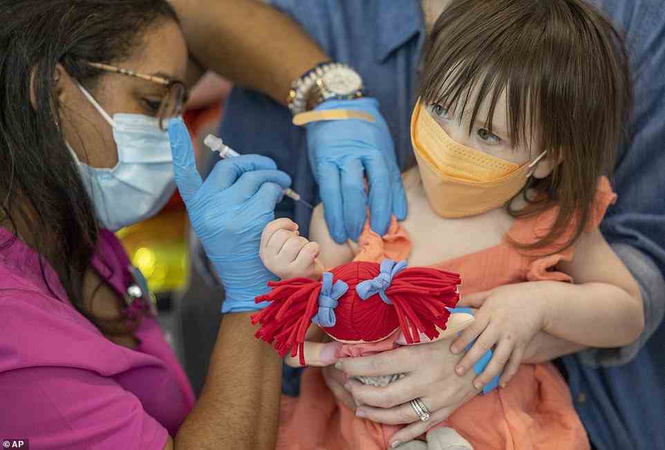 Pictured: A one-year-old girl in New Orleans, Louisiana, holds her toy while she receives a shot of a COVID-19 vaccine
