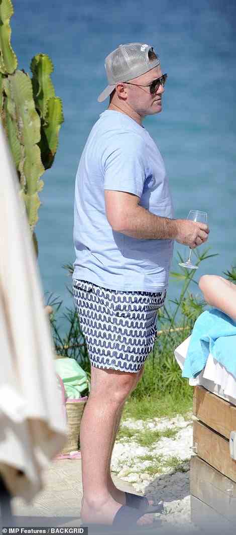 No kids allowed: Husband Wayne was also seen enjoying the beach party, keeping covered up in a pale blue t-shirt and backwards facing baseball cap to ward off the sunburn