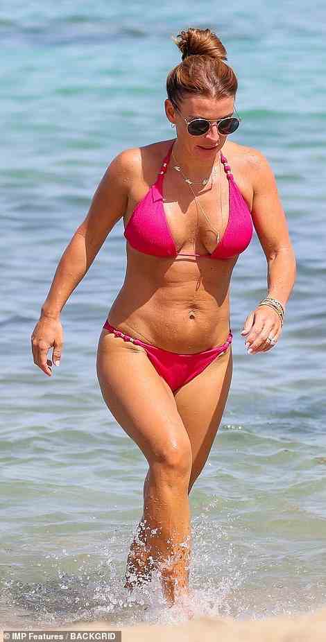 Gorgeous: The skimpy swimwear emphasised the mum of four's toned curves and impressive abs as she strolled out of the ocean and mingled with her pals