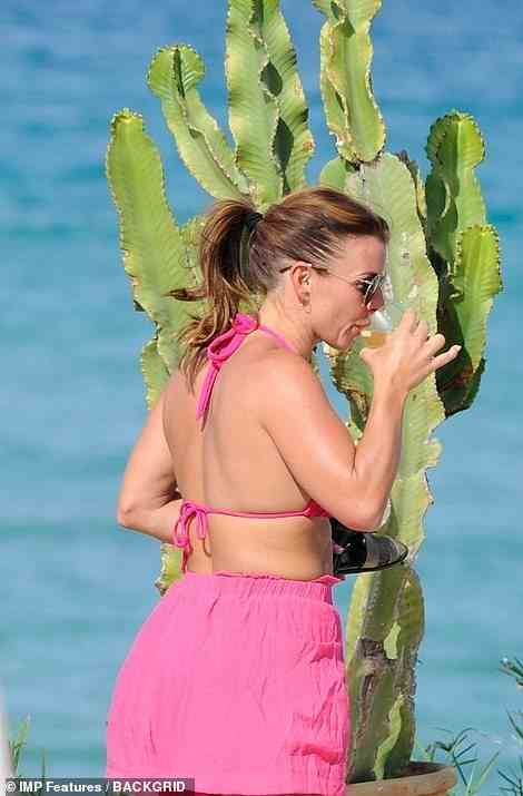 Letting her hair down: Coleen sipped on ice cold drinks in the sizzling temperatures of Ibiza