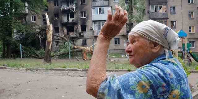 Eine Frau gestikuliert in der Nähe eines Wohnhauses, das während des Beschusses in Donezk auf dem Gebiet unter der Regierung der Volksrepublik Donezk in der Ostukraine beschädigt wurde, Mittwoch, 22. Juni 2022.