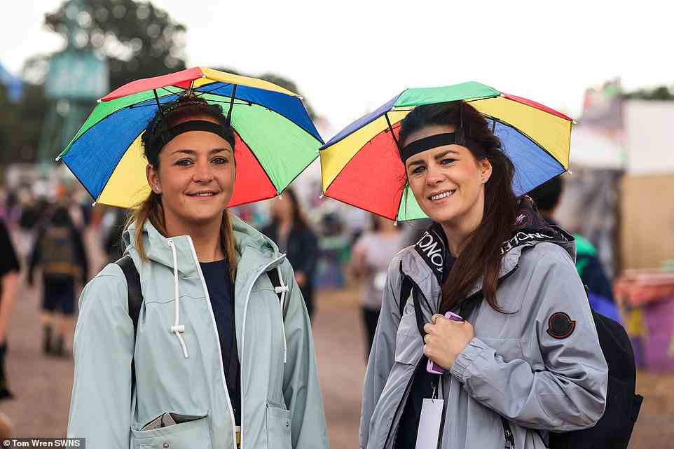 Two young festivalgoers, pictured earlier today, are well-prepared for what's set to be a rainy day ahead