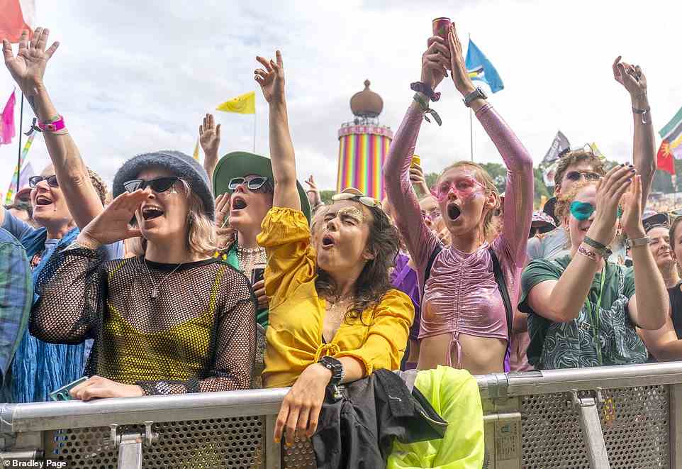 Music fans cheer on performers at one of the smaller stages during day three of the iconic outdoor festival yesterday